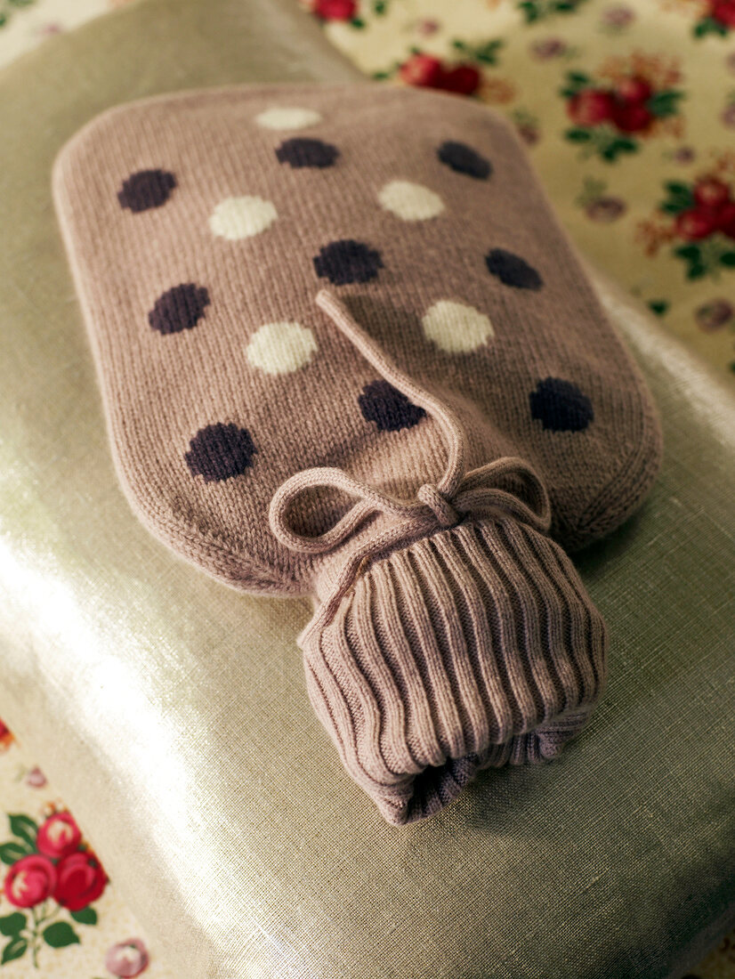 Hot water bottle with knitted polka dot look