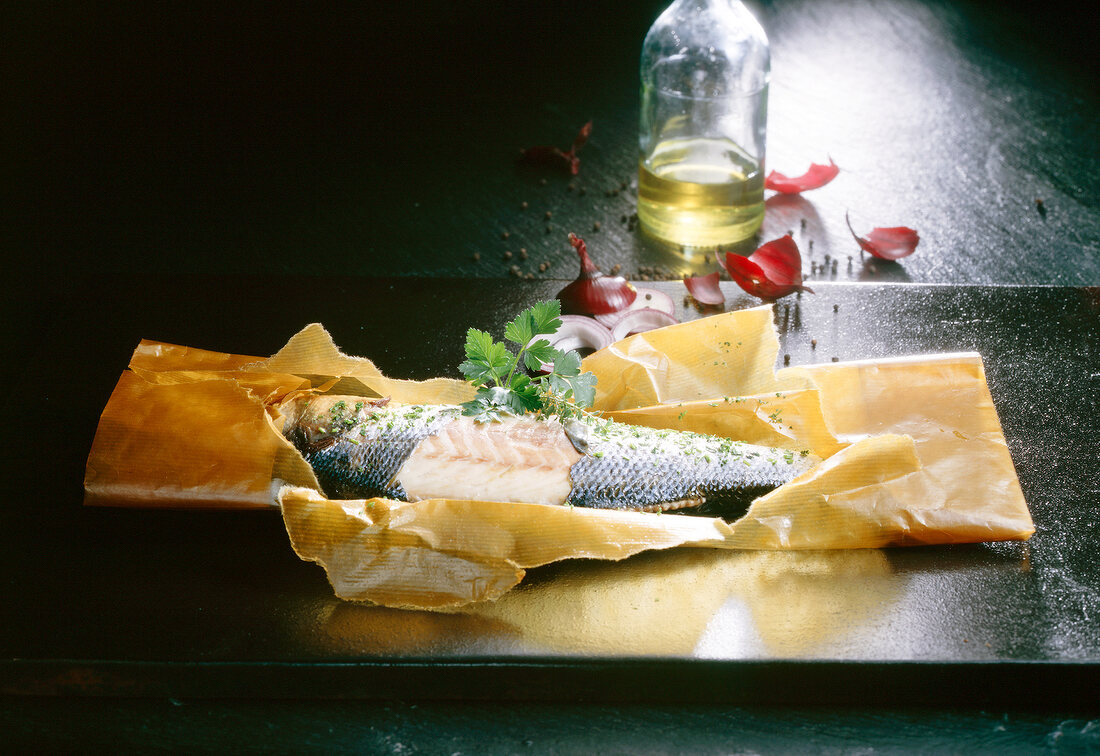 Fisch, Seewolf in Backpapier, Zwiebelringe, öl