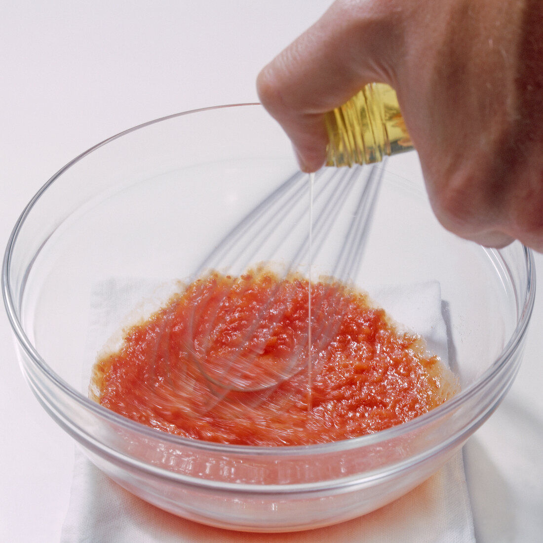 Close-up of olive oil being poured in mixture while whisking, step 5, blurred motion