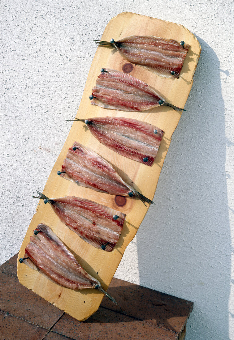 Grilled herring fillets on wooden board