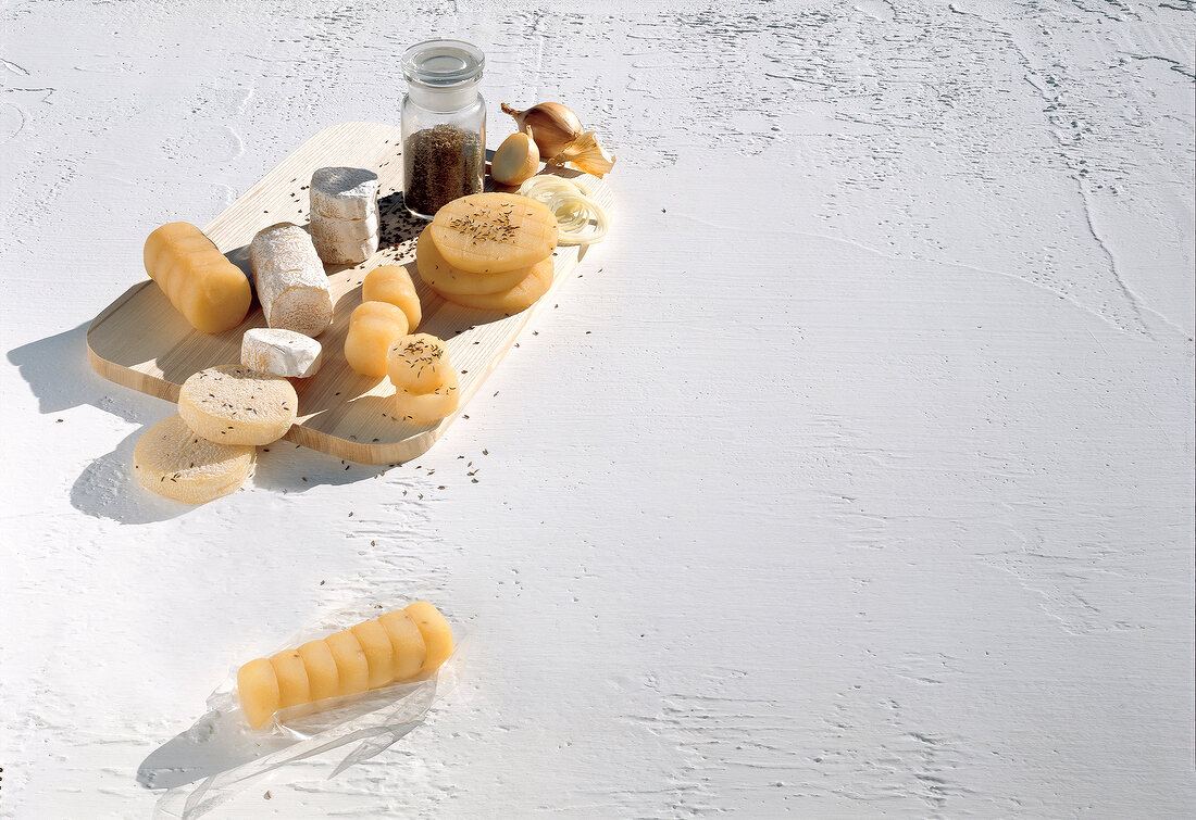 Variety of cheese on wooden board against white background