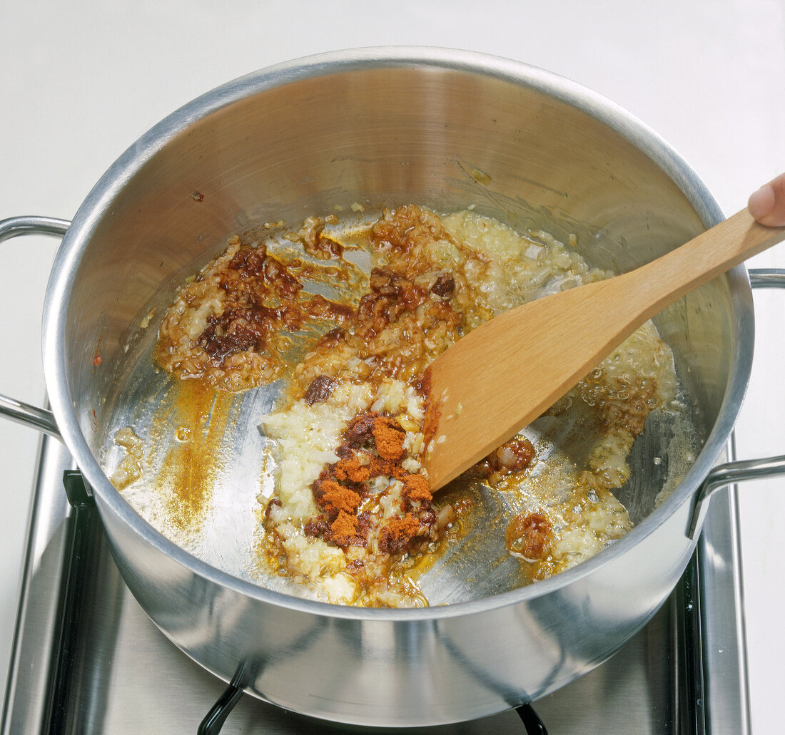 Paprika and onion being stirred in pot, step 3