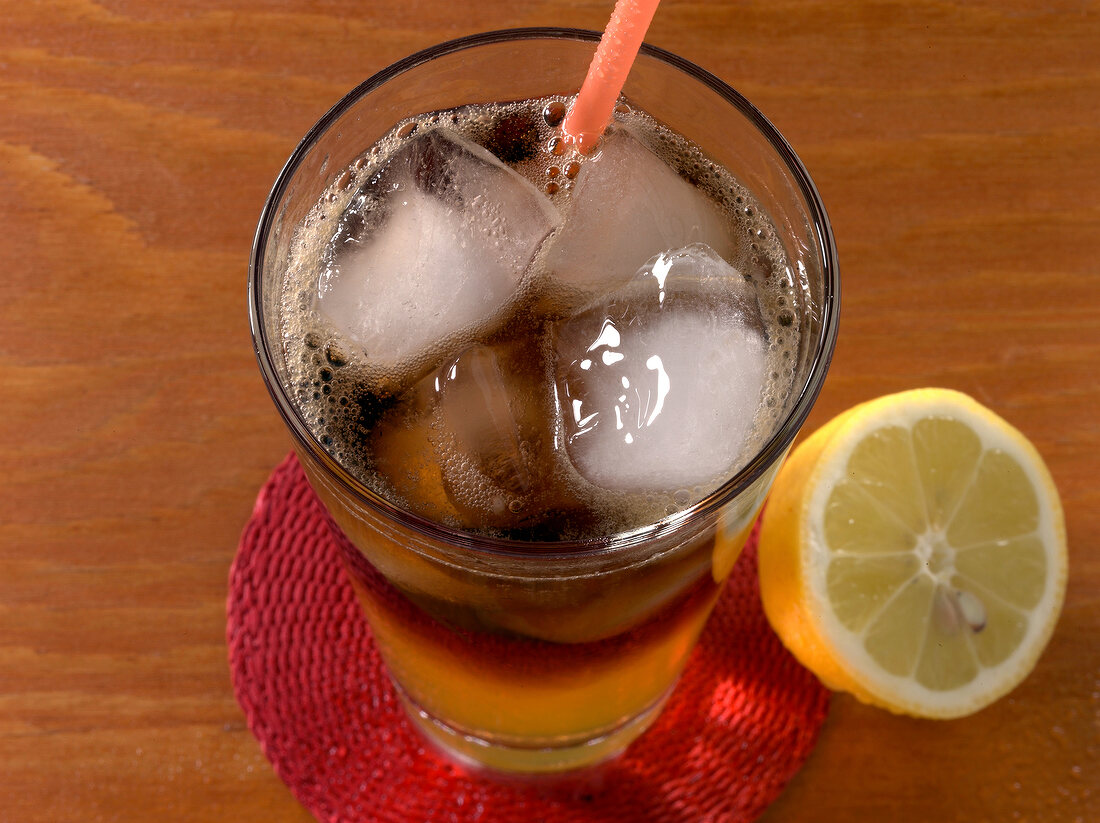 Long iceland iced tea in glass with half lemon besides it