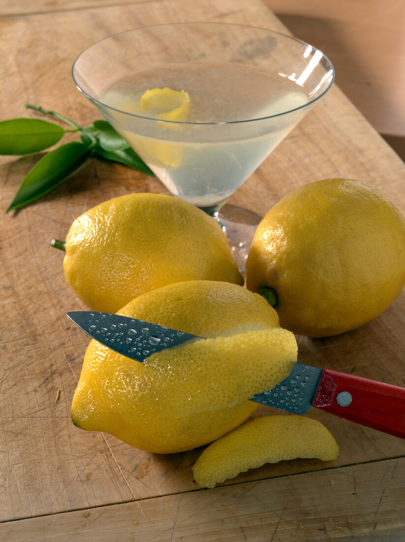 Lemon drink in martini glass besides whole lemon