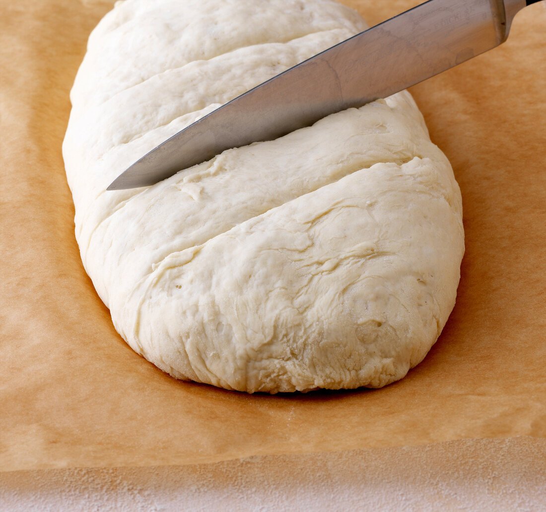 Brot backen - Einschneiden der O berfläche eines Broteigs