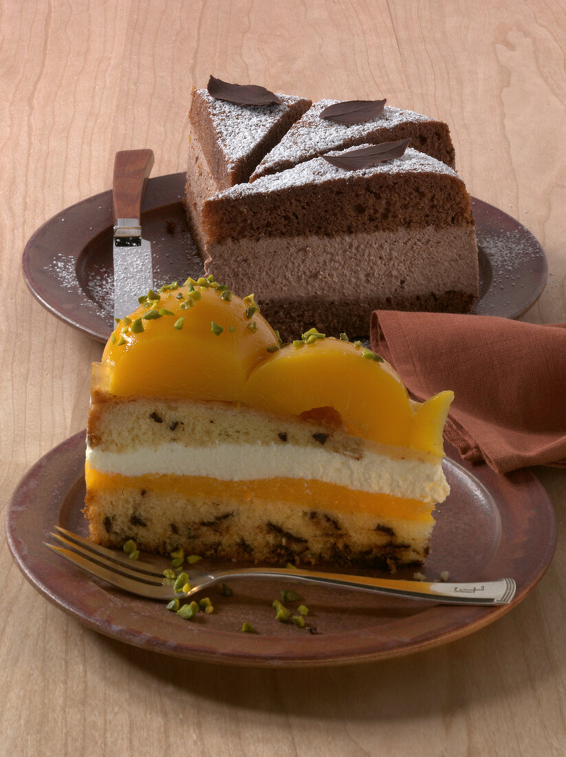 Pieces of chocolate cream cheese cake and peach pie on plate