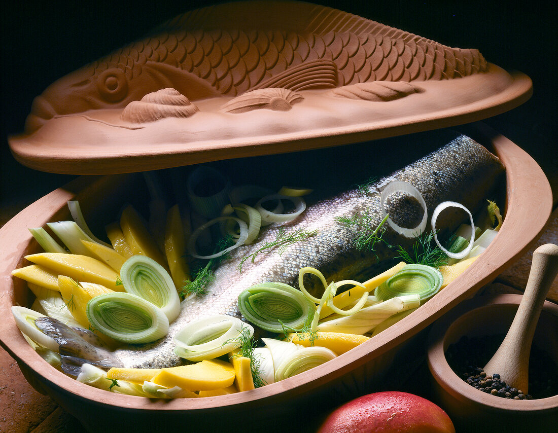 Close-up of salmon trout with mango and fennel in serving dish