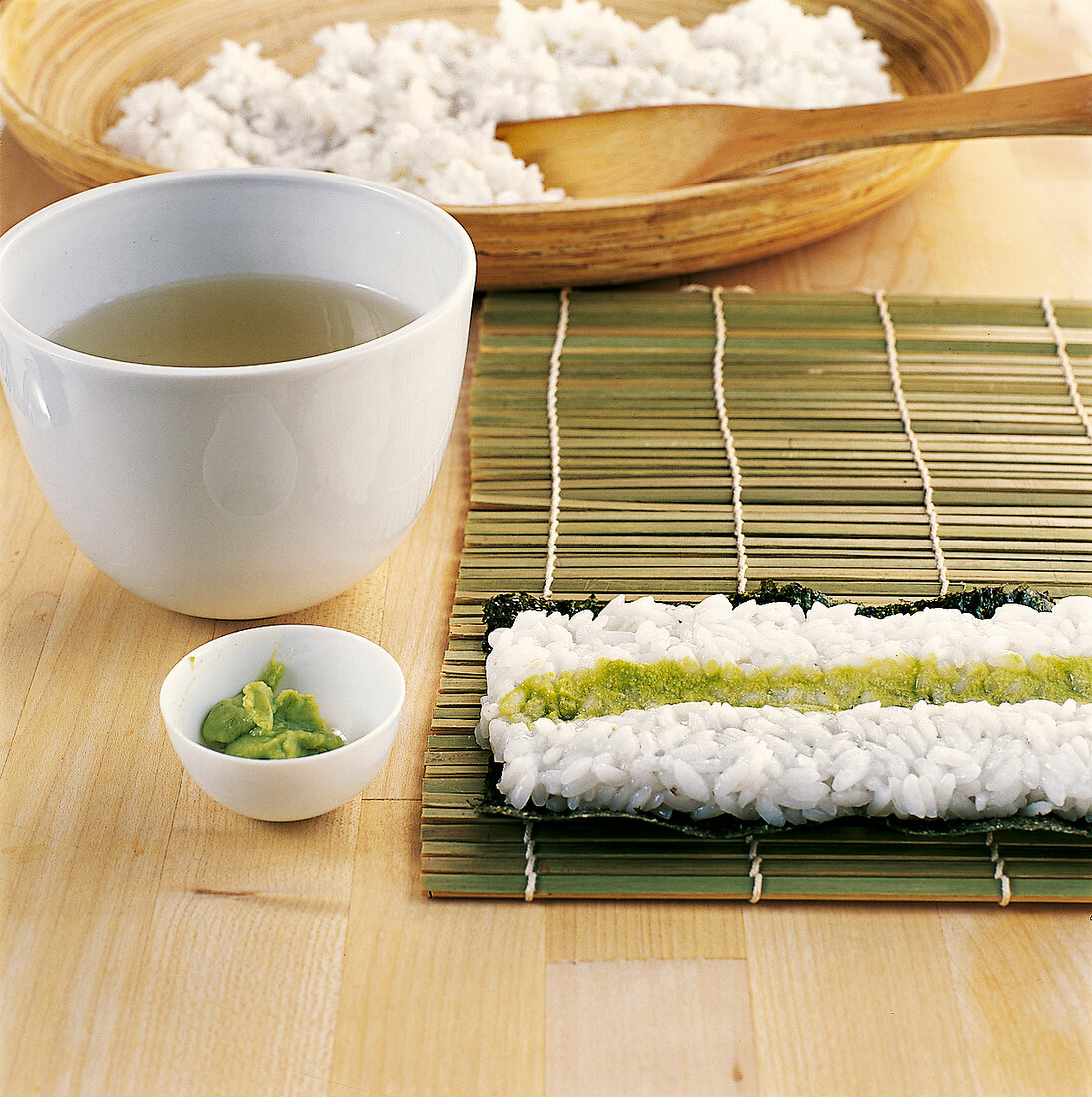 Sushi - Wasabipaste wird in Reis mitte gestrichen