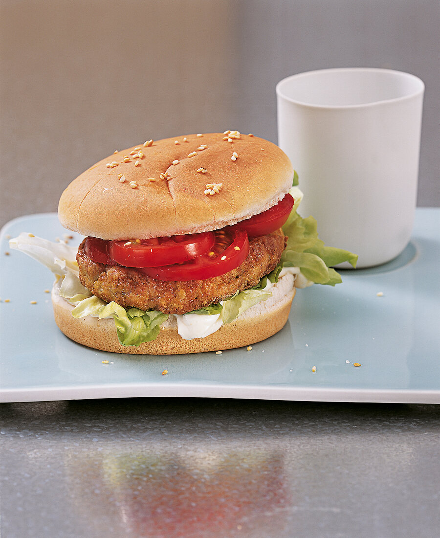 Fisch - Seelachs-Burger mit Tomaten auf Teller