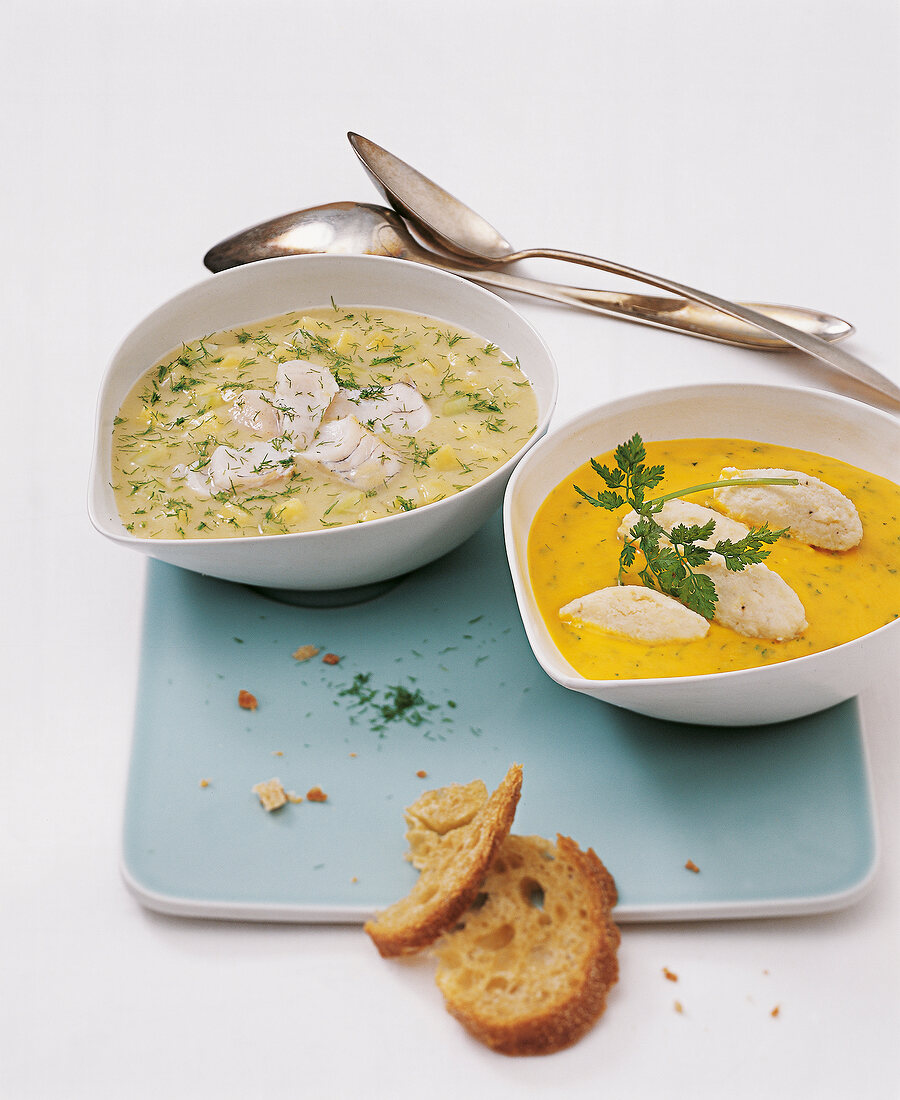 Cream of fennel soup with zander and carrot soup with trout in bowls