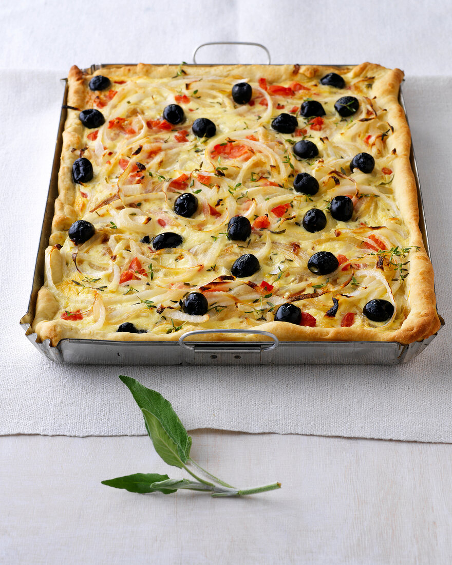 Provencal tomato, onion and olive quiches on baking tray
