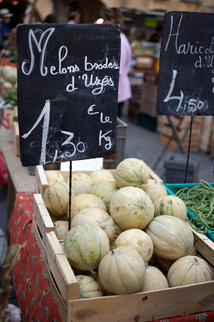 Close-up of charentais melons in wooden box at market