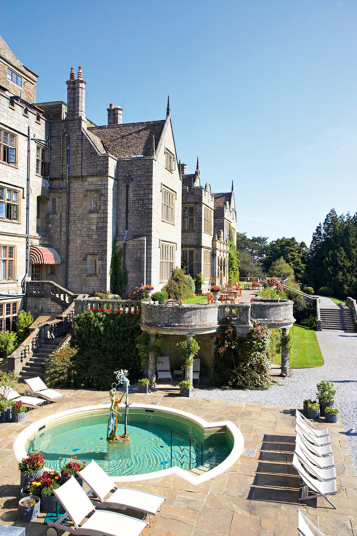 View of hotel Bovey Castle with garden and loungers in front, Devon, UK