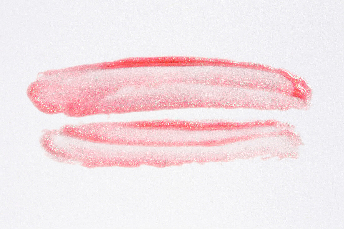 Close-up of scribbled bright pink lipstick on white background