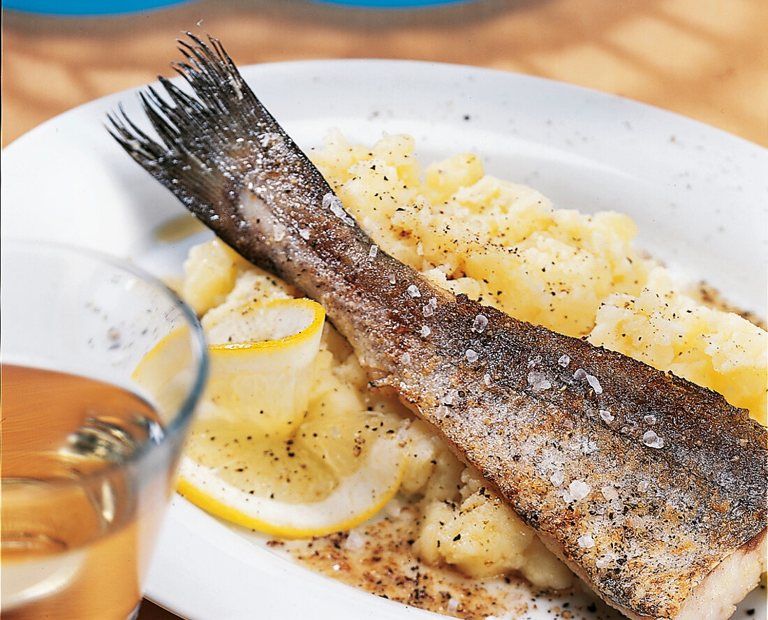 Close-up of fried redfish fillet with garlic sauce on plate