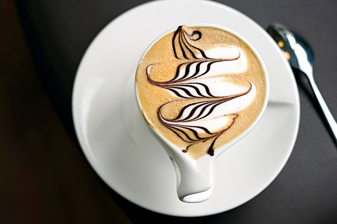 Tasse Kaffee, Milchschaum mit Schokoladenwellen verziert