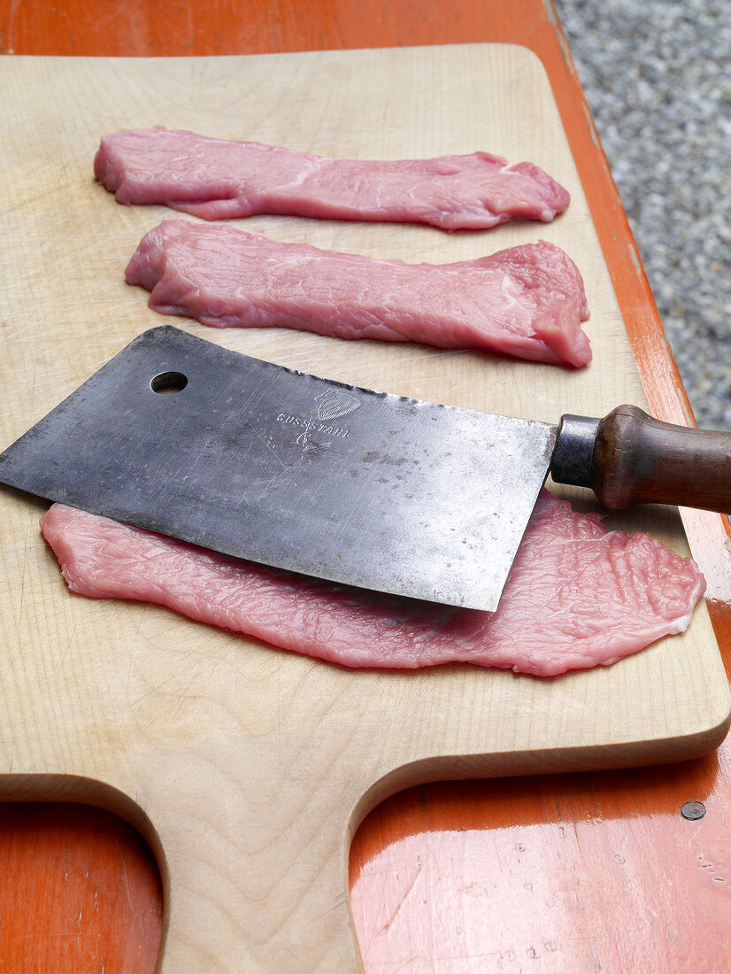 Flat veal on chopping board for preparation of barbecues, step 1