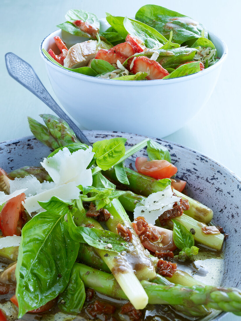 Spinach, strawberries, asparagus and parmesan salad in bowl with spoon