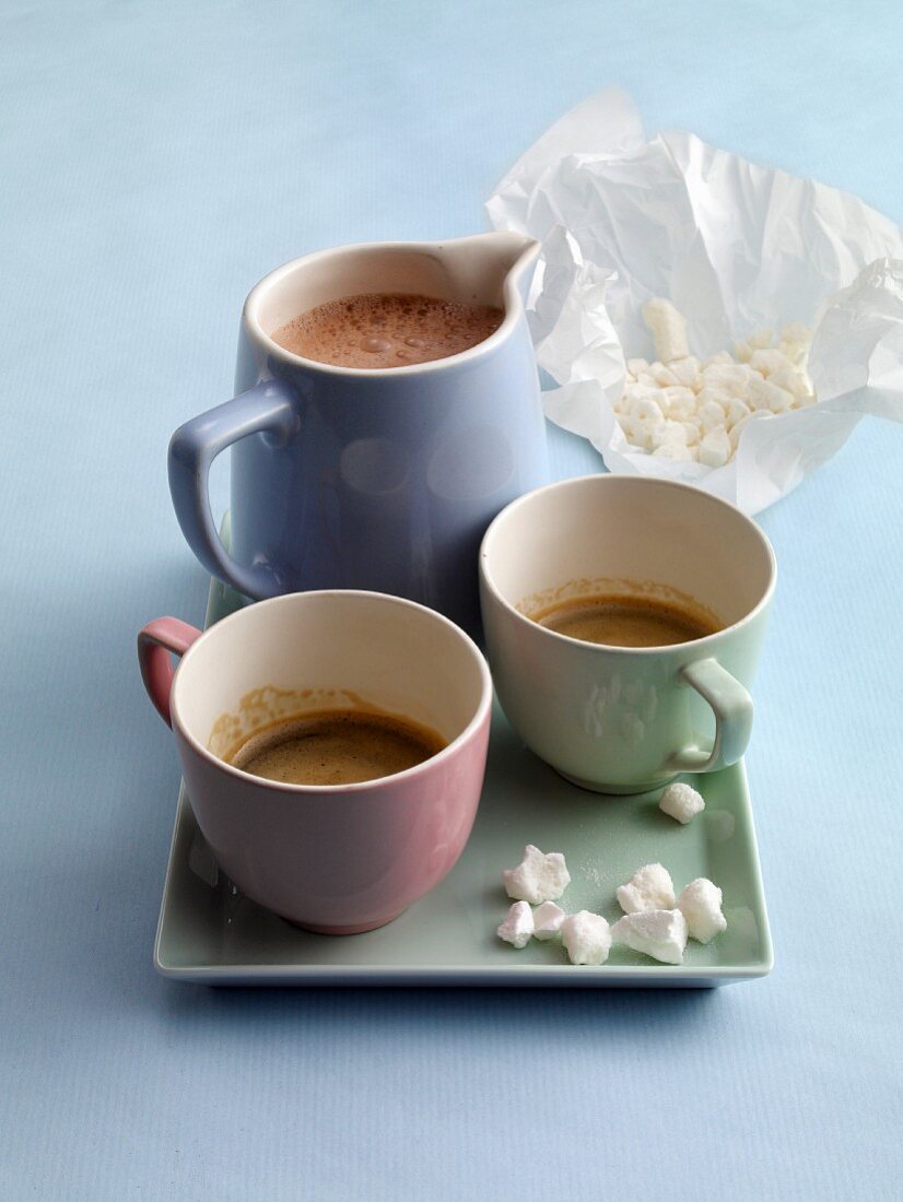 Espresso, chococcino with meringue sprinkles, cups and a jug
