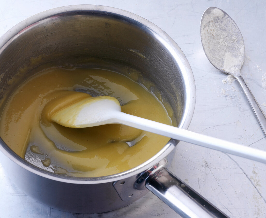 Butter melted in saucepan with spatula for preparation of bechamel sauce, step 1