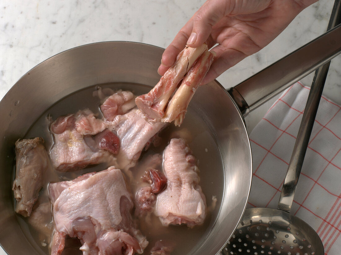 Giblets and bones being boiled in pan, step 1