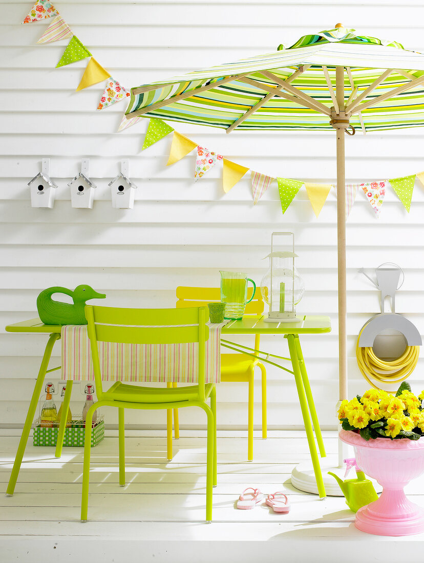 Grüner Gartentisch, gelber, grüner Stuhl, Sonnenschirm, Vogelhäuser