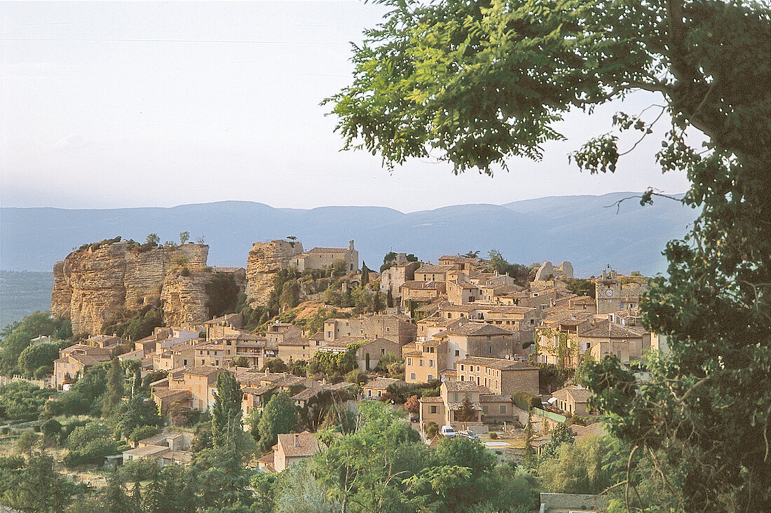 Blick auf Saignon, braune Häuser, im Hintergrund Gebirge, Provence