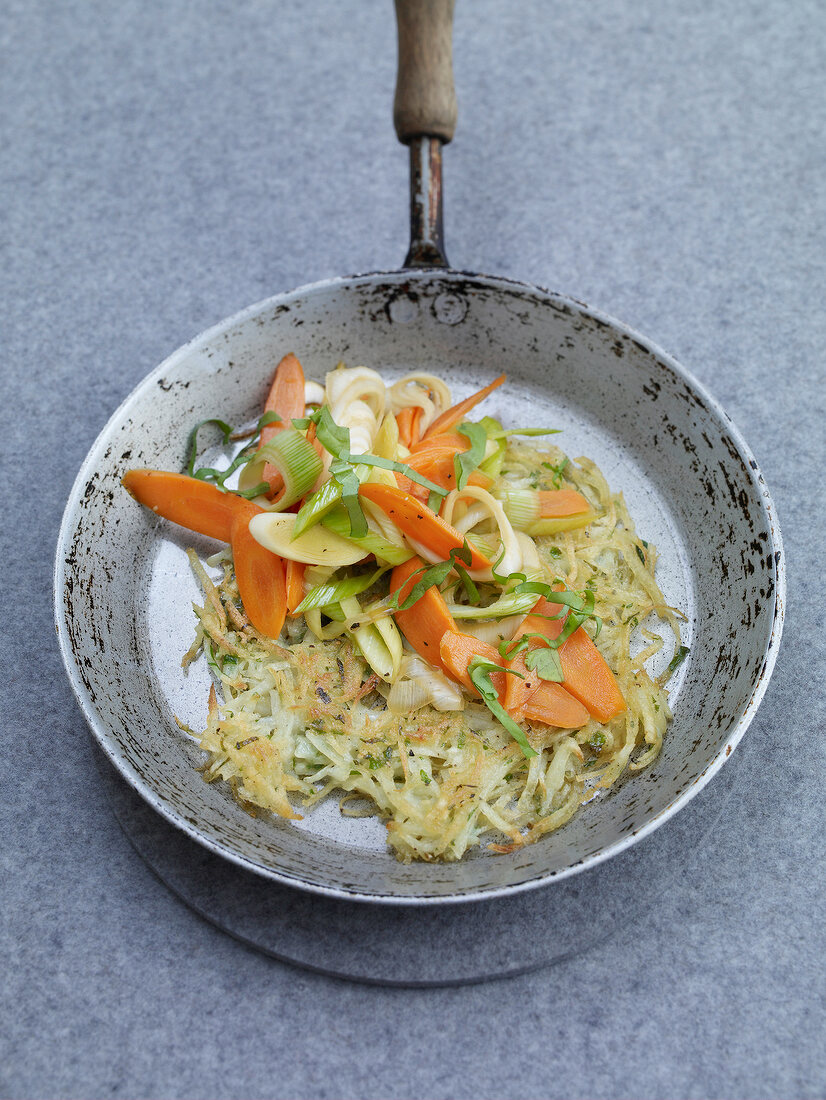 Wild garlic rosti with caramelized vegetables in pan