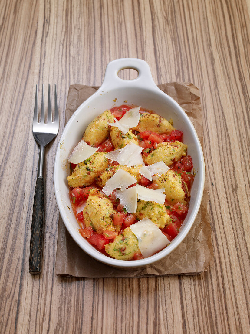 Gnocchi with wild garlic, melted tomatoes and parmesan in serving dish