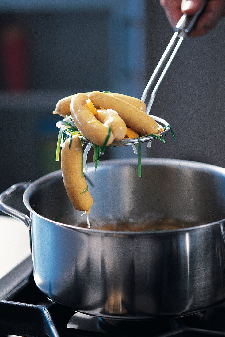 Pumpkin sausages being taken out from pan with trowel