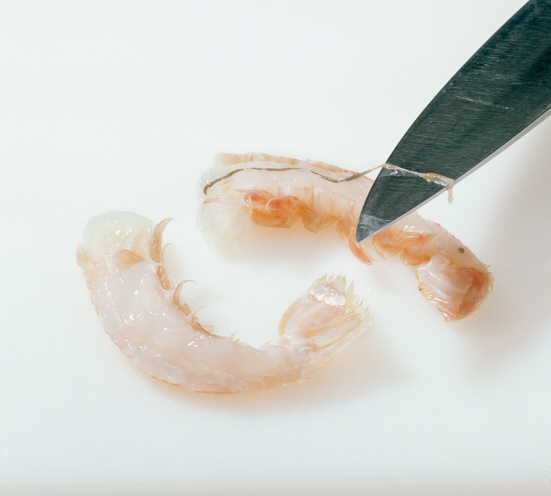 Close-up of intestine of shrimp on knife, step 2