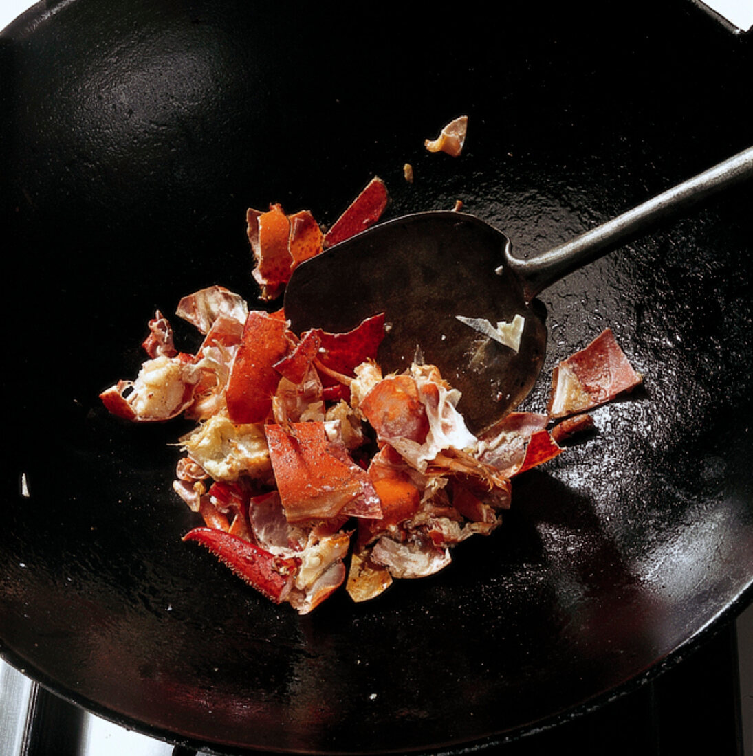 Shrimps, Hummerfond: Karkassen -teile im Wok anbraten, Step 7