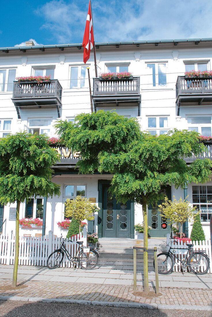 Facade of Skovshoved Hotel with balcony and bicycles parked at the fence, Denmark
