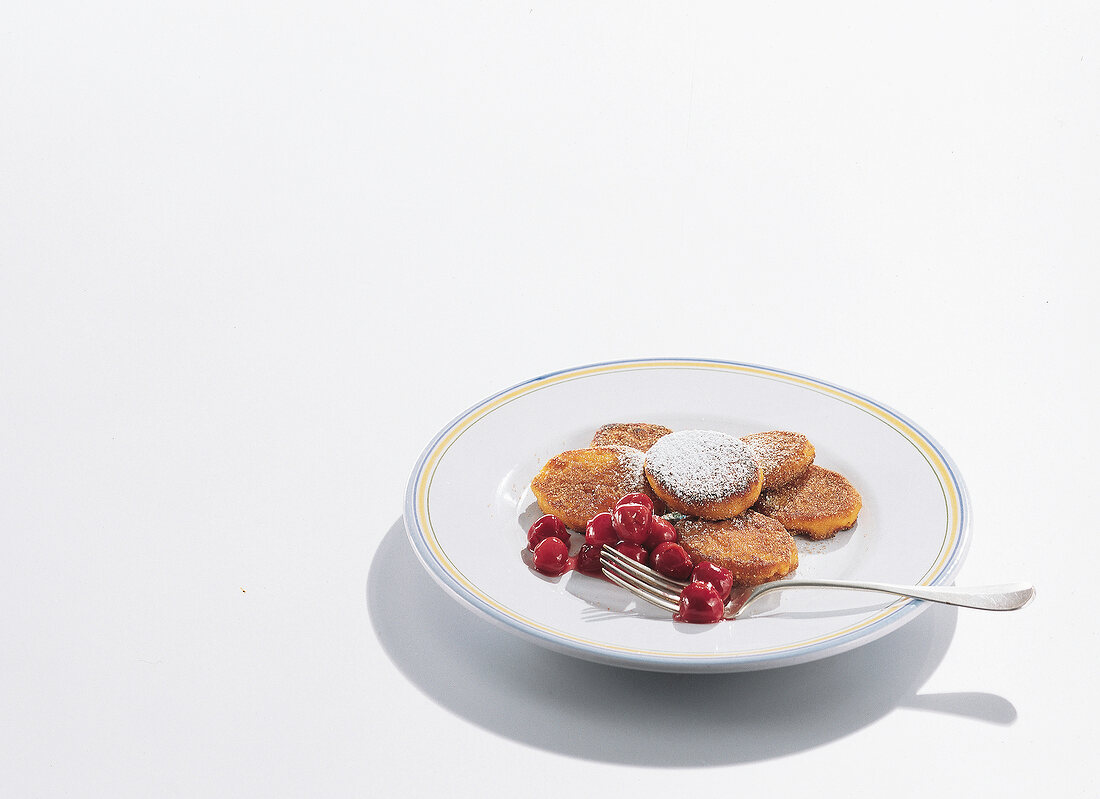 Pumpkin pancakes with sour cherry compote on plate