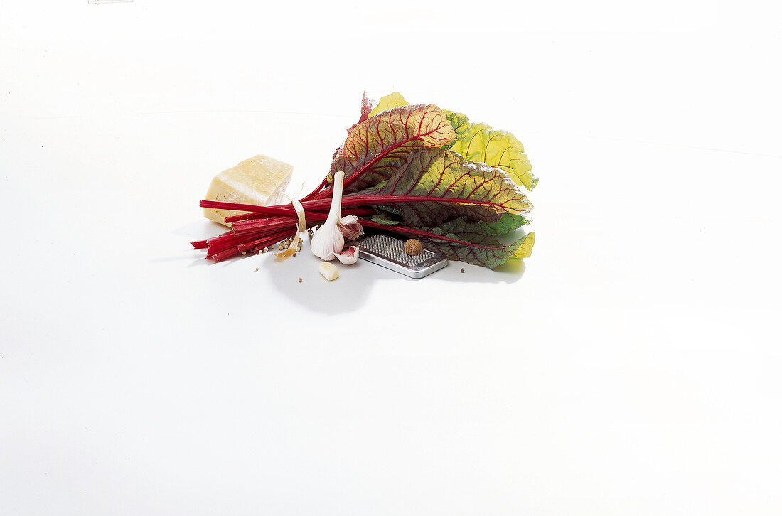Chard leaves, garlic, cheese and grater on white background