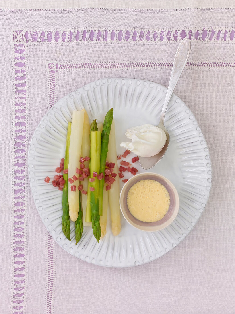 Asparagus with poached egg ham and mustard hollandaise on plate