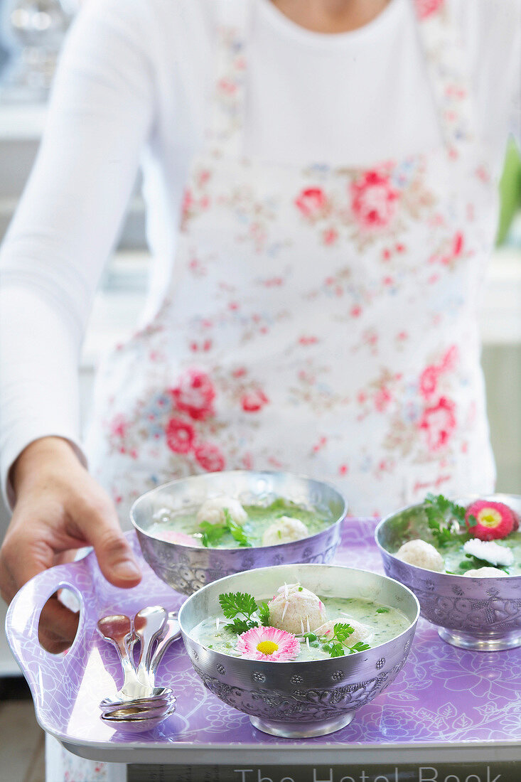 Close-up of woman serving three bowls of soup