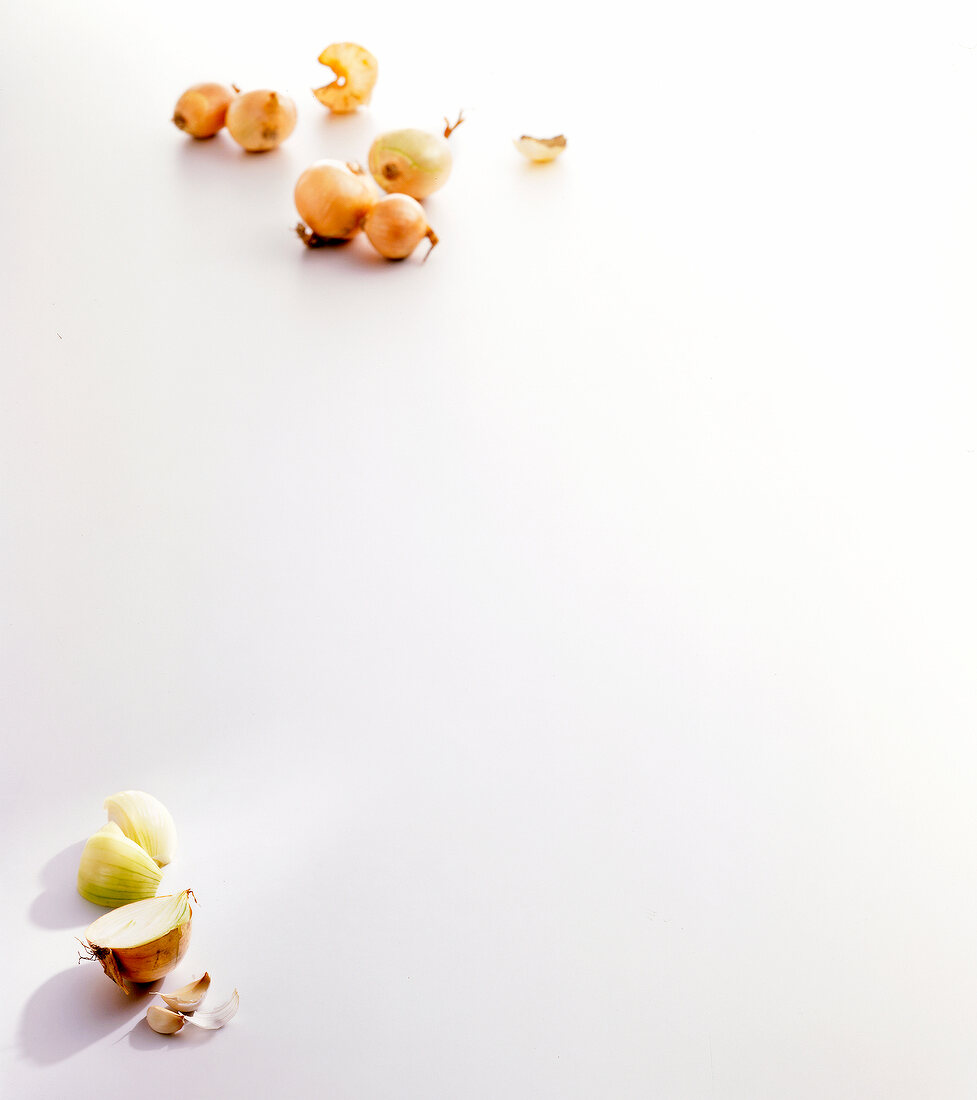 Half onion and cloves of garlic on white background
