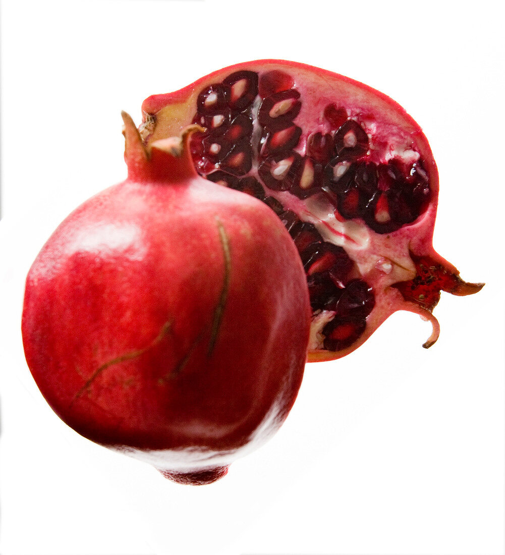 Close-up of halved pomegranate on white background