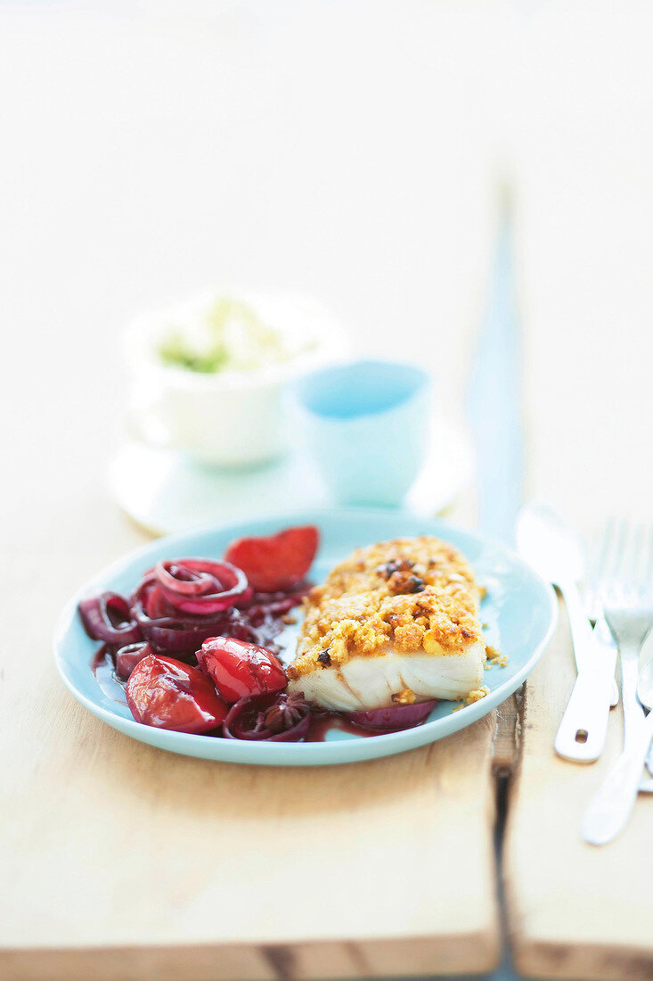 Baked hake with plum sauce on plate