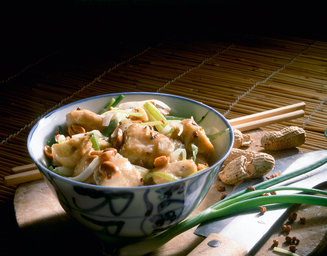 Bowl of marinated chicken with peanuts and spring onions