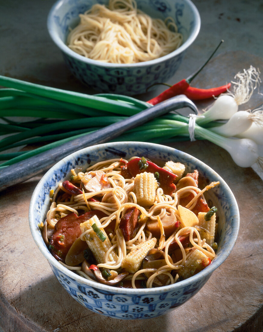 Duck with noodles, corn, spring onions and chilli in bowl