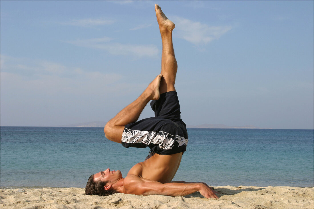 Man doing stretching exercise on the beach