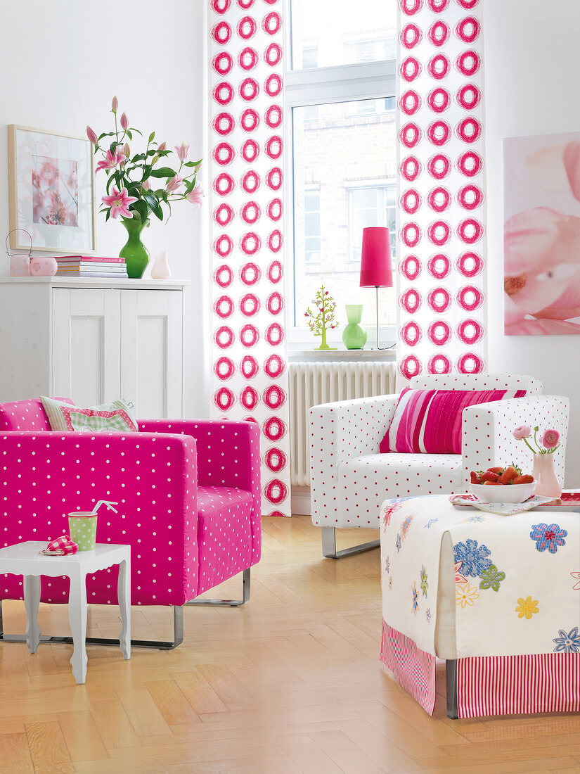 Pink dotted white chair and white curtains with pink circles against window