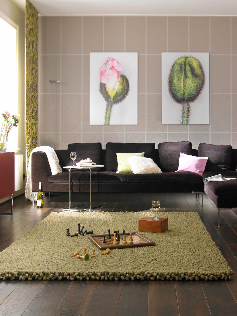 Living room with large brown sofa, green carpet and flower painting on wall