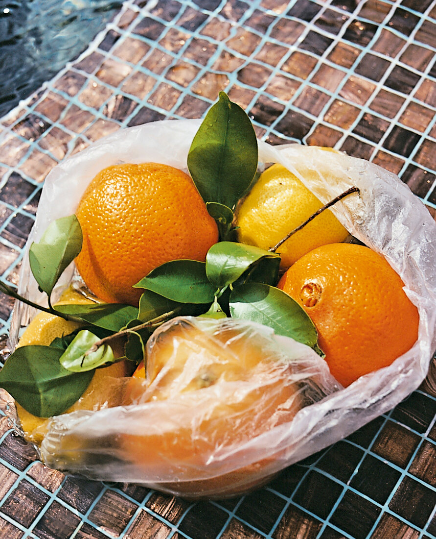 Orangen mit Blättern in einer Plasti ktüte