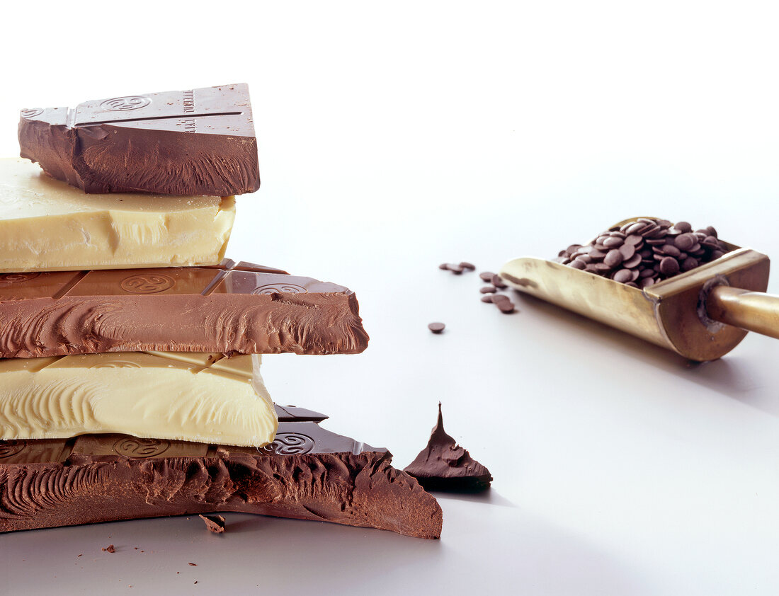 Stack of chocolate with scoop of wafers on white background
