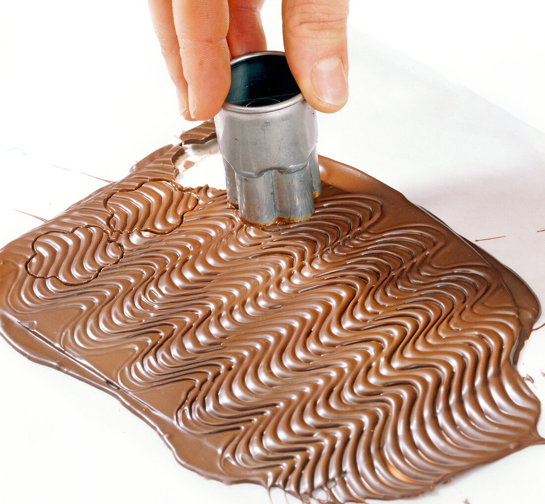 Hand cutting chocolate with wavy pattern with cutter