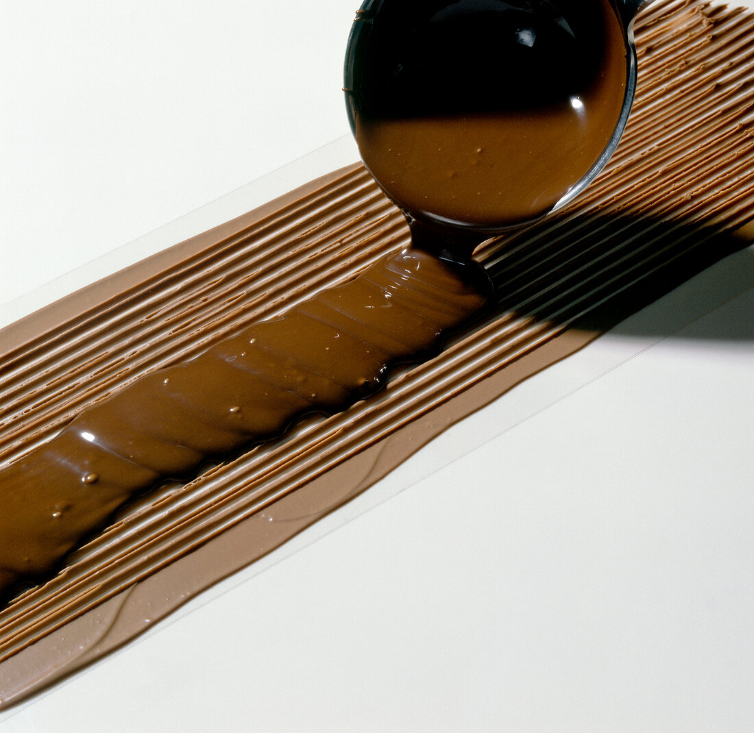 Close-up of dark chocolate being poured on lighter chocolate, step 3