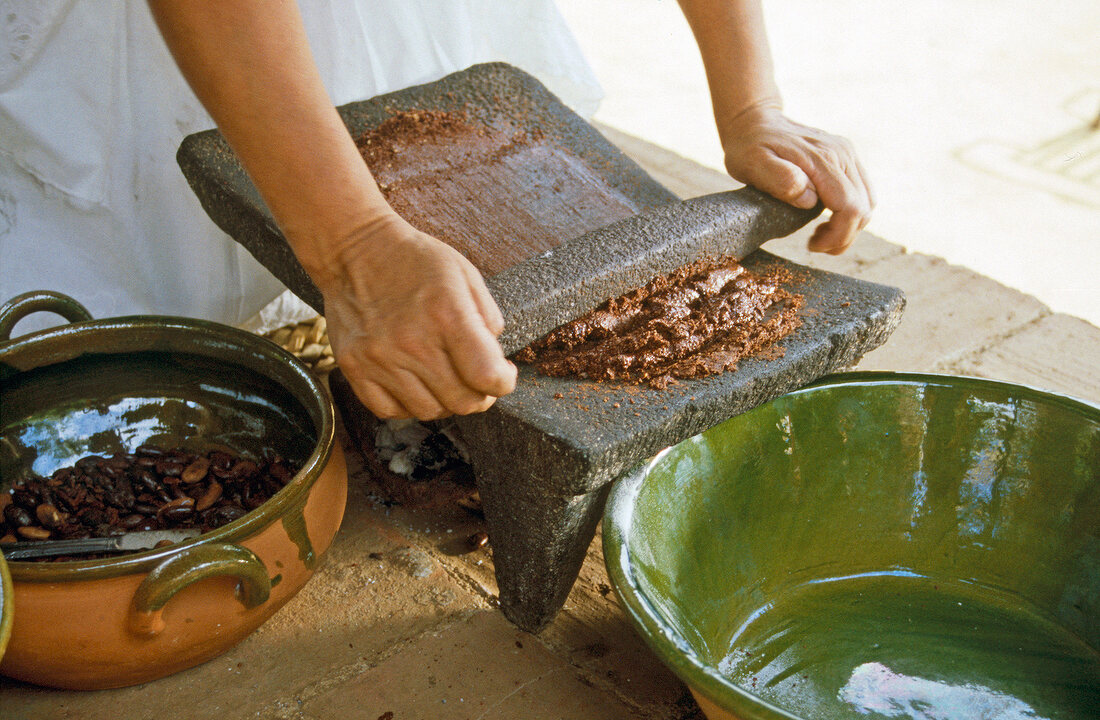 Buch der Schokolade, Frau zermahlt Kakaopulver zur Fettmasse